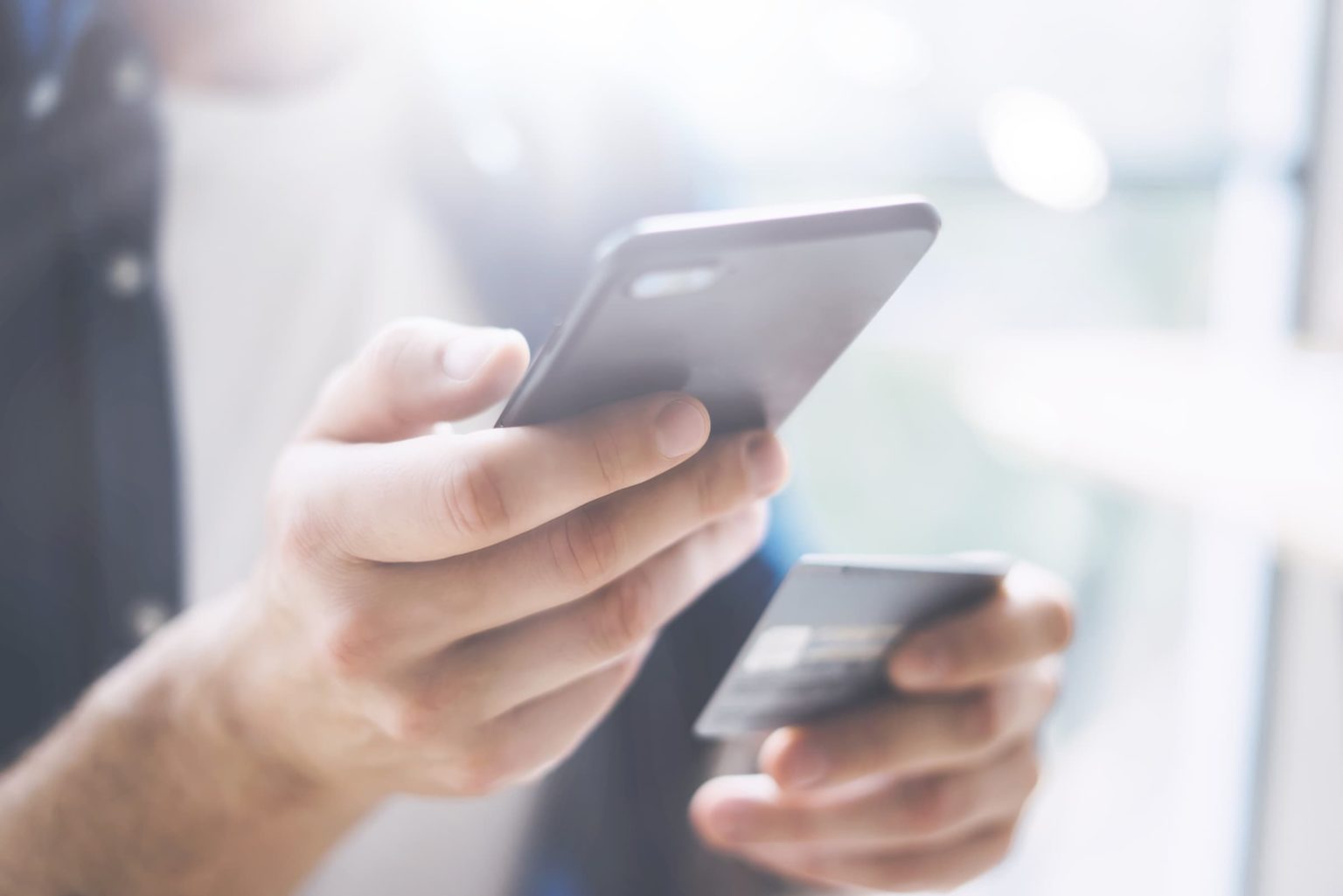 Hands holding smartphone and credit card